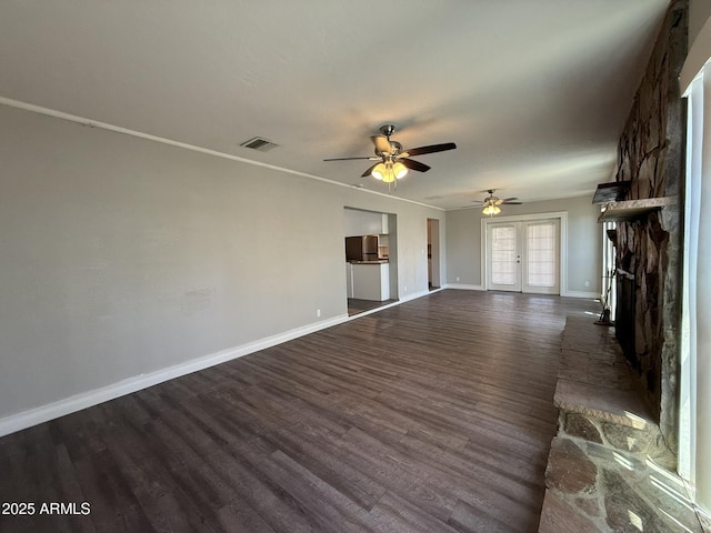 unfurnished living room with baseboards, a ceiling fan, visible vents, and dark wood finished floors