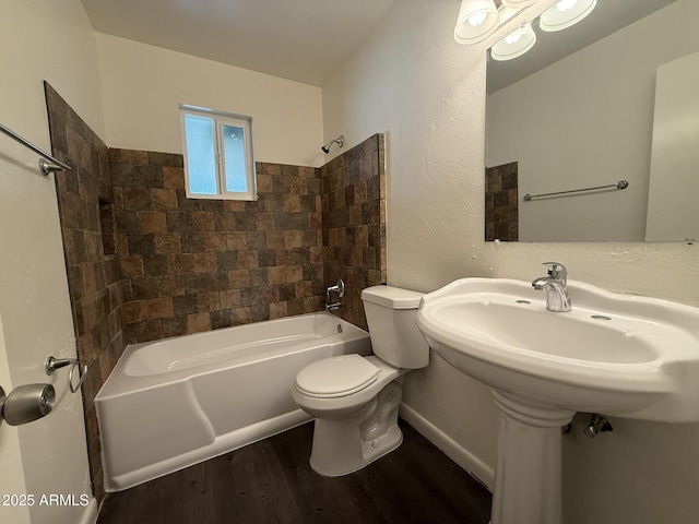 bathroom featuring toilet, baseboards, wood finished floors, and shower / tub combination