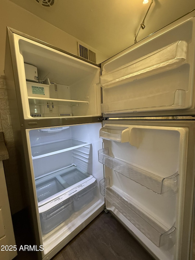 room details with fridge and dark wood-type flooring