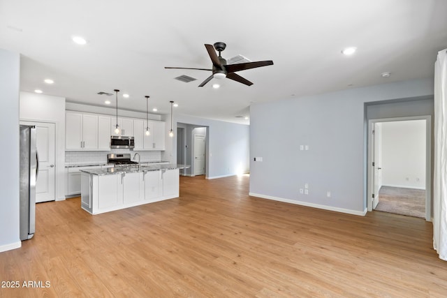 kitchen with light wood-type flooring, open floor plan, white cabinetry, ceiling fan, and appliances with stainless steel finishes