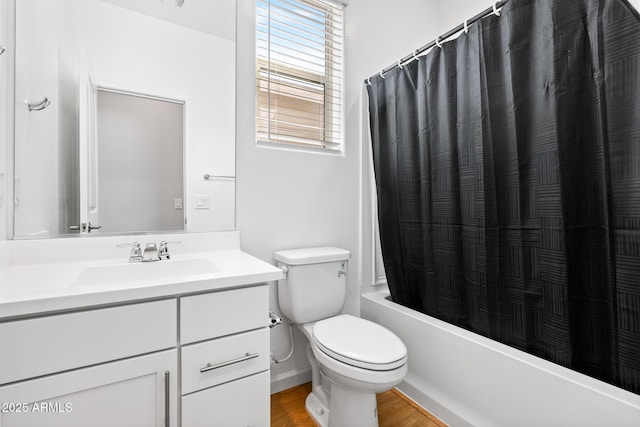 bathroom featuring shower / bath combination with curtain, vanity, toilet, and wood finished floors