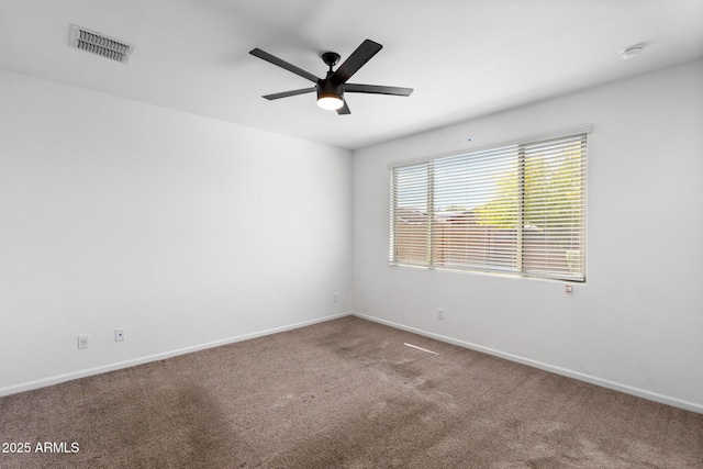 spare room with visible vents, baseboards, a ceiling fan, and carpet
