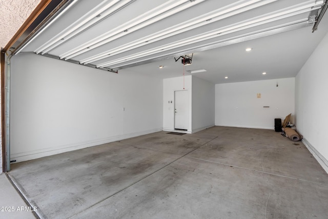 garage featuring a garage door opener and baseboards