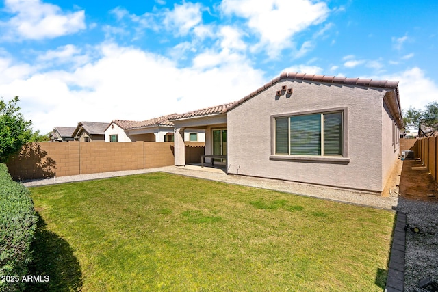 rear view of property featuring a patio, a fenced backyard, stucco siding, and a lawn