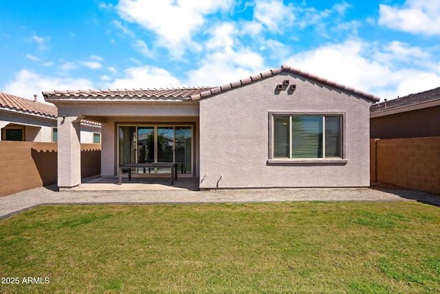 rear view of property featuring a patio, stucco siding, fence, and a lawn