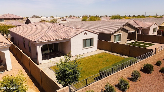 exterior space with a yard, stucco siding, a fenced backyard, and a tile roof