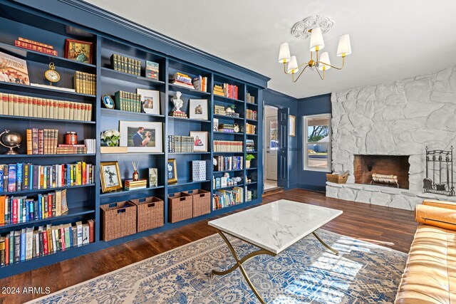 sitting room featuring crown molding, a notable chandelier, dark hardwood / wood-style flooring, and a fireplace