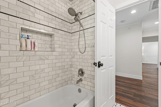 bathroom featuring tiled shower / bath combo, ornamental molding, and hardwood / wood-style floors