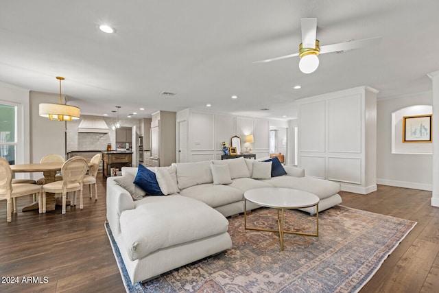 living room with ornamental molding, dark hardwood / wood-style floors, and ceiling fan