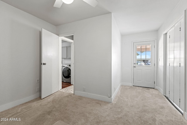 washroom with washer / dryer, light colored carpet, cabinets, and ceiling fan