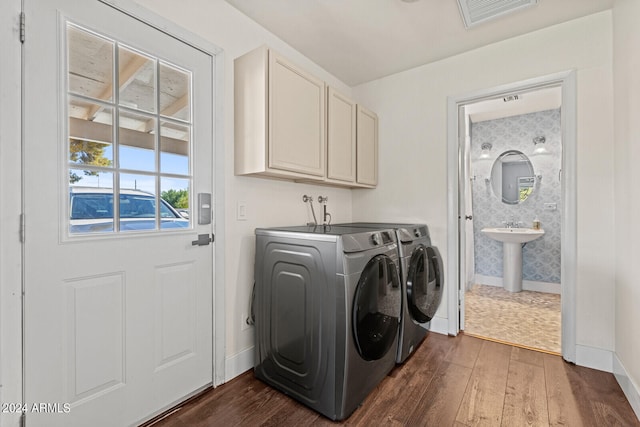 washroom featuring cabinets, dark hardwood / wood-style floors, sink, and separate washer and dryer