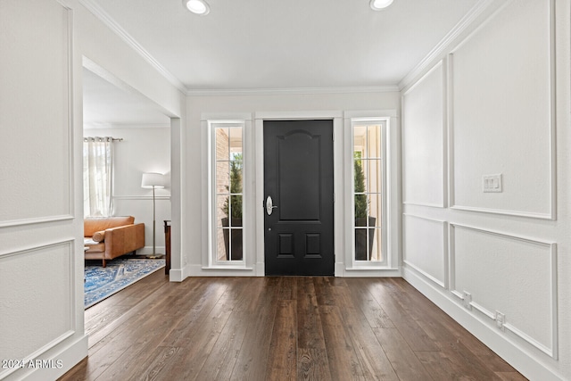 entrance foyer with ornamental molding and dark hardwood / wood-style flooring