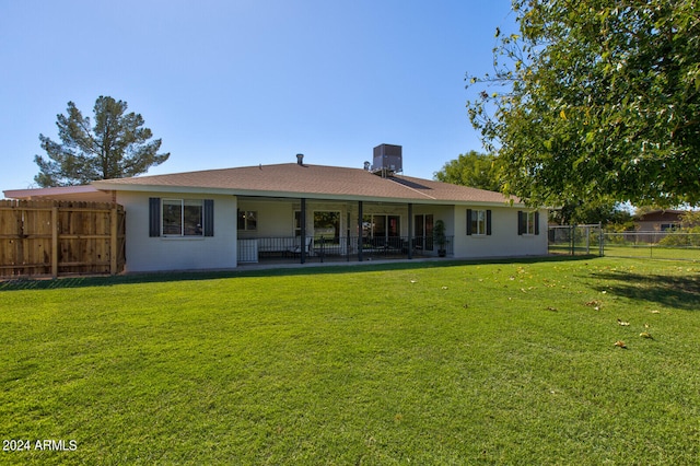 back of house with a patio and a lawn