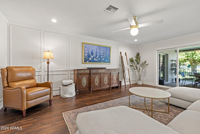 living room with dark wood-type flooring, ceiling fan, and ornamental molding