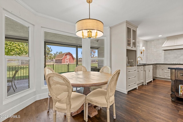 dining space with dark wood-type flooring, ornamental molding, and sink