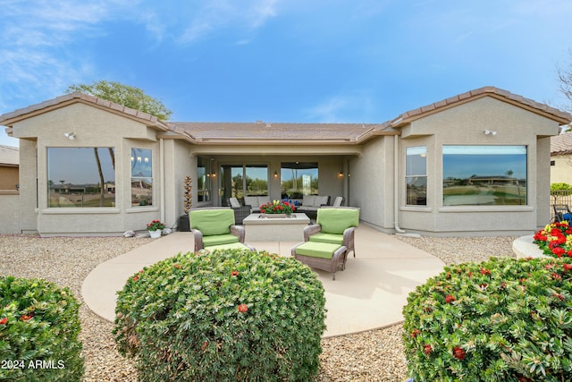 back of property with outdoor lounge area and a patio area