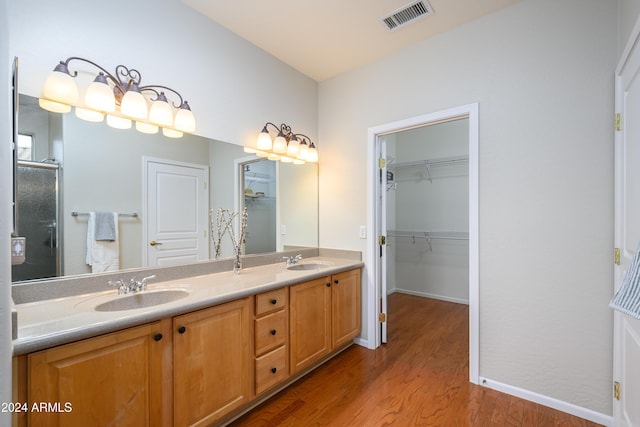 bathroom with vanity, an enclosed shower, and wood-type flooring