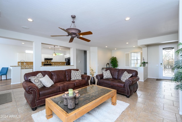 living room featuring ceiling fan and sink