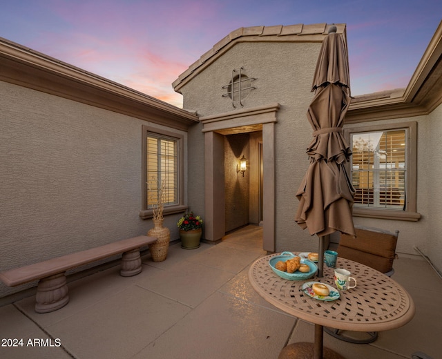 exterior entry at dusk featuring a patio