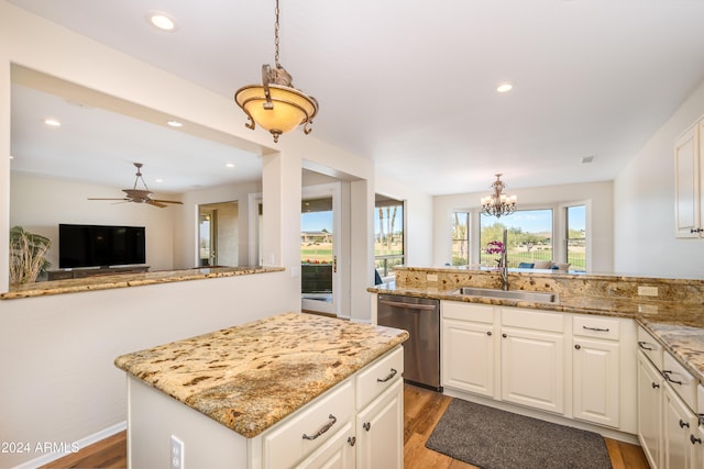 kitchen with white cabinets, dishwasher, sink, and decorative light fixtures