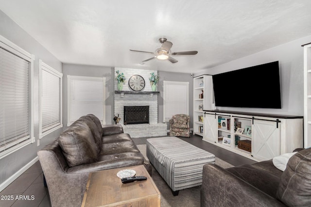 living room with a brick fireplace and a ceiling fan