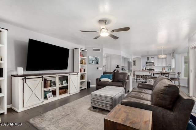 living room featuring visible vents, built in shelves, and a ceiling fan