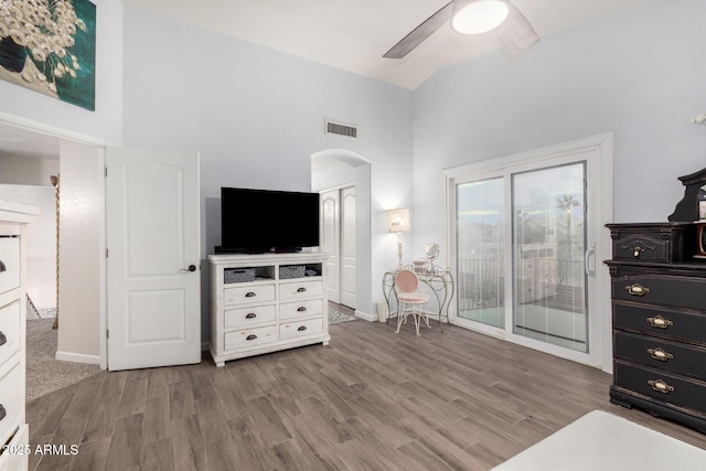 sitting room featuring arched walkways, visible vents, a ceiling fan, and wood finished floors