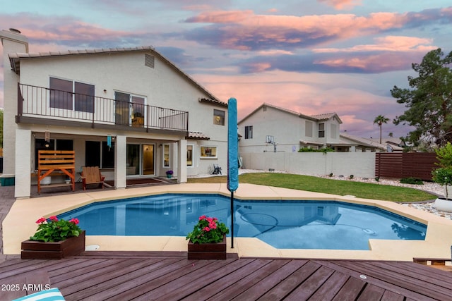 pool at dusk featuring a fenced in pool, a patio area, and fence