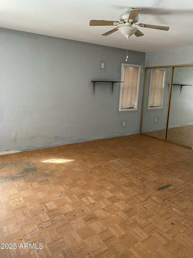 unfurnished room with a textured ceiling and a ceiling fan