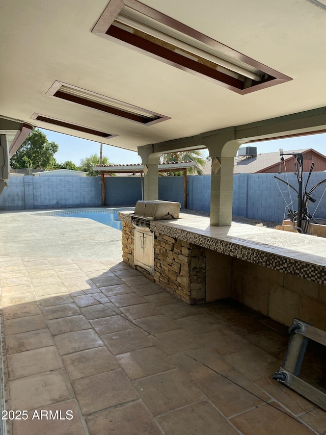 view of patio featuring area for grilling, a fenced backyard, and a grill