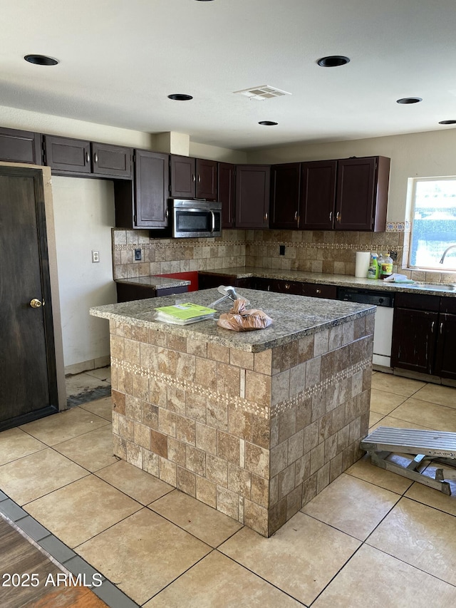 kitchen featuring dishwasher, light tile patterned floors, stainless steel microwave, and decorative backsplash