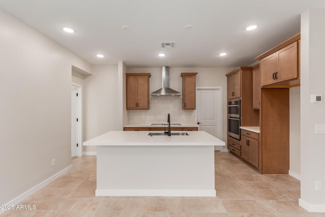 5678 N 205th Ln, Buckeye, AZ 85396 - kitchen featuring wall chimney exhaust hood, double oven, backsplash, an island with sink, and recessed lighting