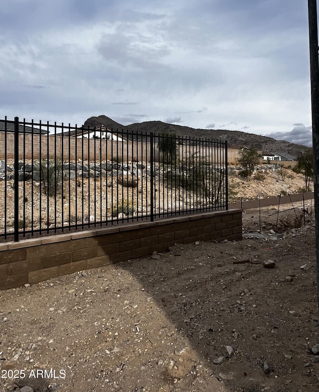 view of gate featuring a mountain view and fence