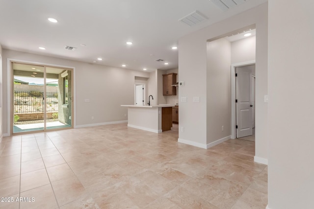 5678 N 205th Ln, Buckeye, AZ 85396 - unfurnished living room with recessed lighting, light tile patterned flooring, a sink, and baseboards