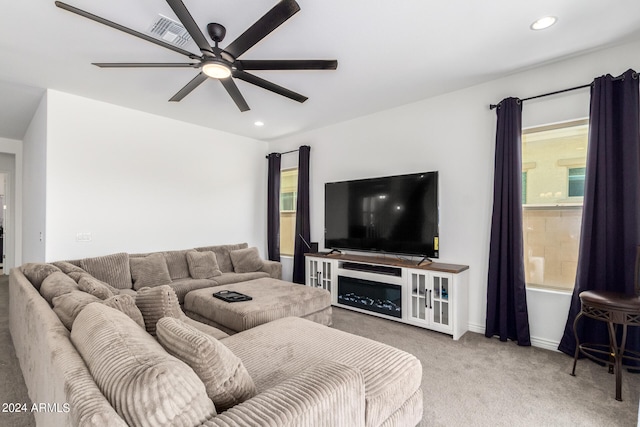 carpeted living room with ceiling fan and plenty of natural light