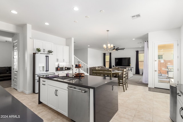 kitchen with sink, an island with sink, white refrigerator with ice dispenser, white cabinetry, and stainless steel dishwasher