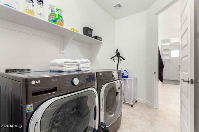 washroom featuring washer and dryer and light tile patterned flooring