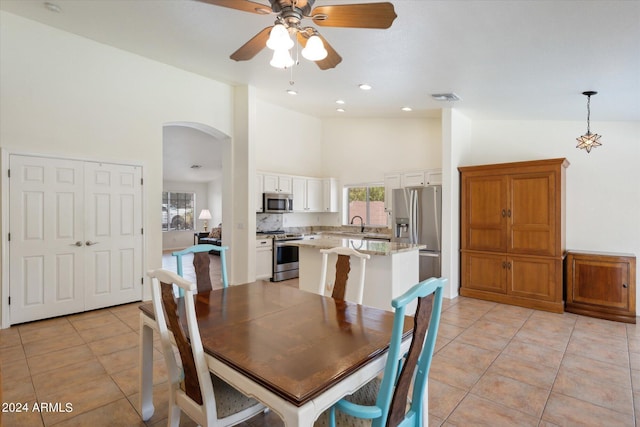 dining space featuring light tile patterned floors, high vaulted ceiling, and ceiling fan