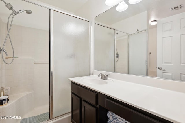 bathroom with vanity and a shower with shower door