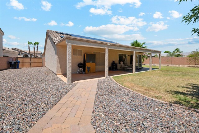 rear view of house featuring a patio area and a lawn