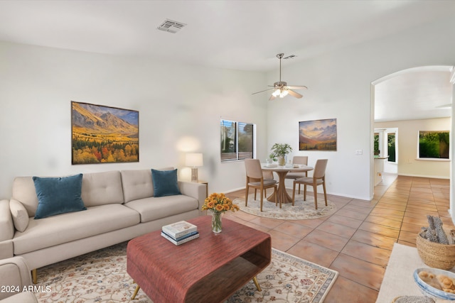 tiled living room featuring ceiling fan and vaulted ceiling