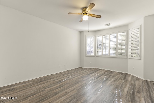 spare room featuring ceiling fan and dark wood-type flooring