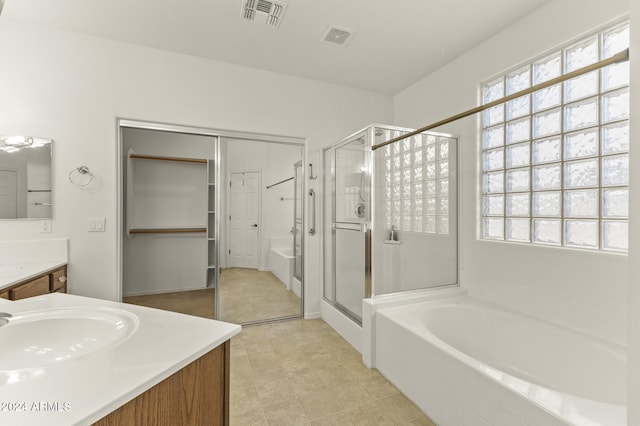 bathroom with tile patterned flooring, vanity, and independent shower and bath