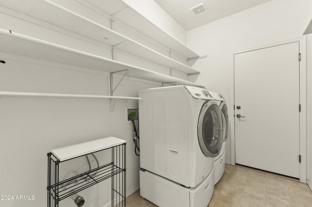 laundry room featuring independent washer and dryer and light tile patterned floors