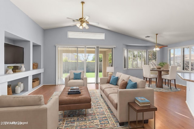 living room with ceiling fan, vaulted ceiling, and light hardwood / wood-style flooring