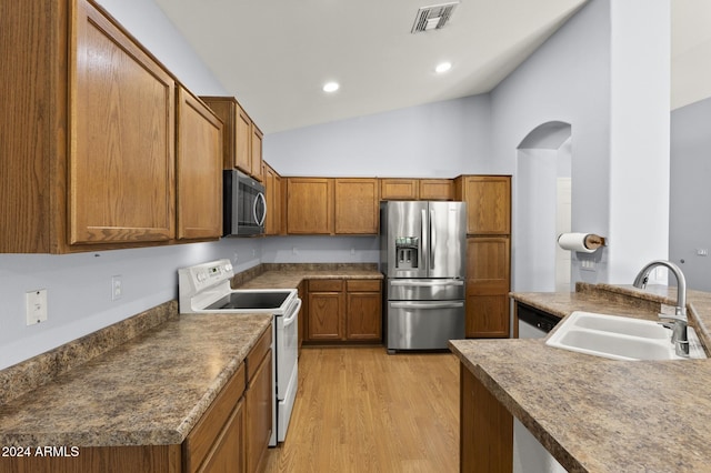 kitchen with light hardwood / wood-style floors, sink, lofted ceiling, and stainless steel appliances