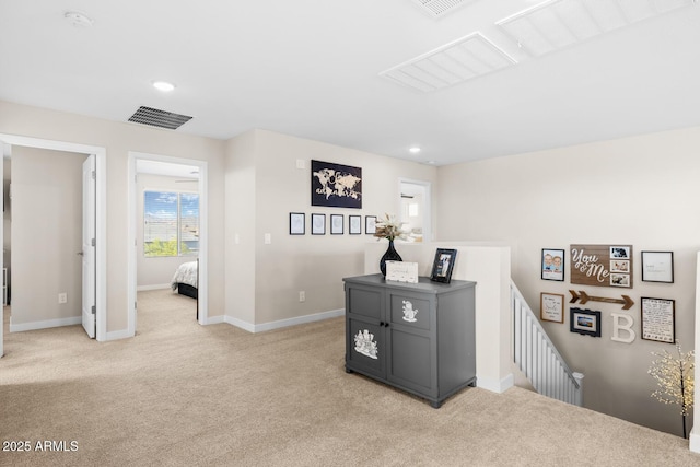 corridor with recessed lighting, an upstairs landing, visible vents, baseboards, and light colored carpet