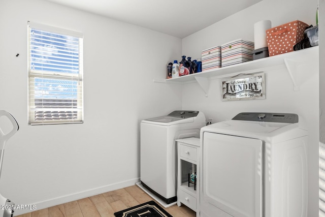 laundry area with baseboards, washing machine and clothes dryer, laundry area, and light wood-type flooring