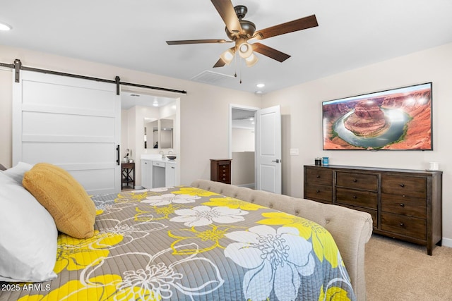 bedroom with carpet flooring, visible vents, a barn door, ensuite bathroom, and recessed lighting