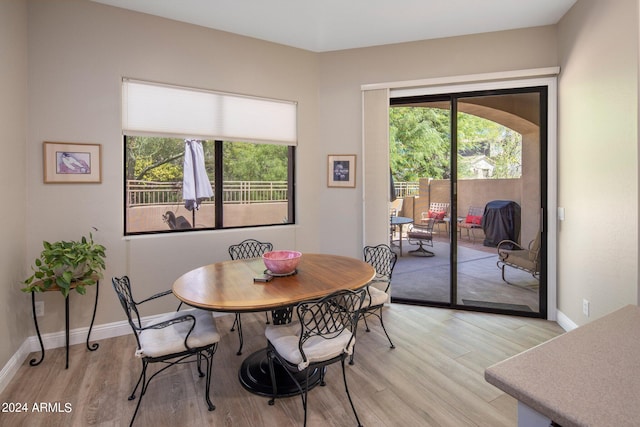 dining area with light wood-style floors and baseboards